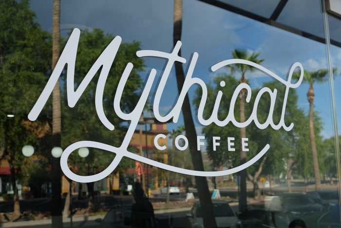 A glass window with the words "Mythical Coffee" written on it