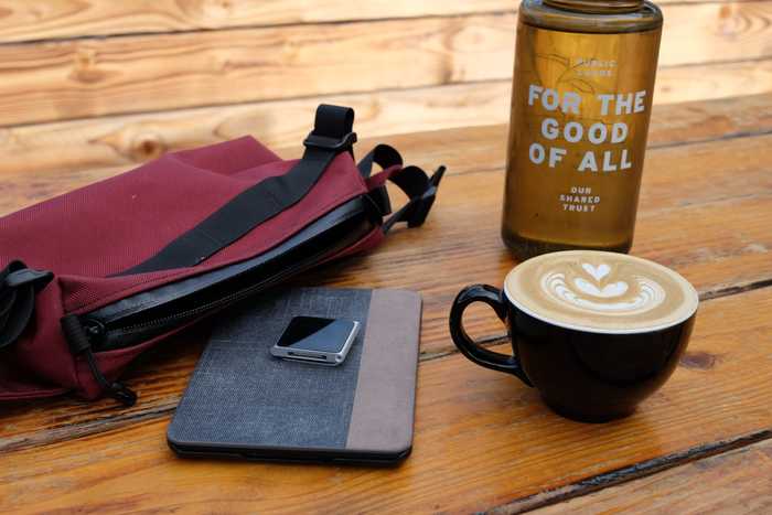 A table with a Kindle, iPod Nano, and latte