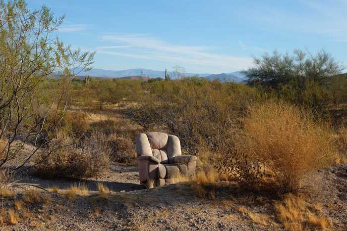A reclining chair sitting in the middle of a Sonoran desert landscape